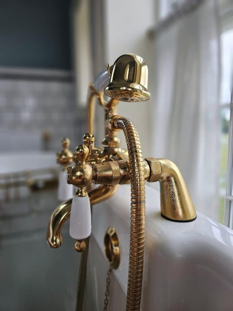 Close-up of a luxurious gold vintage faucet with a classic design in a stylish bathroom setting.